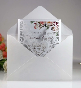 Detail of laser-cut heart and floral lace wedding invitation with white envelope