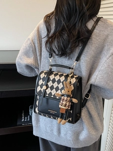 Classic check pattern backpack with leather trim and cute rabbit charm on a model