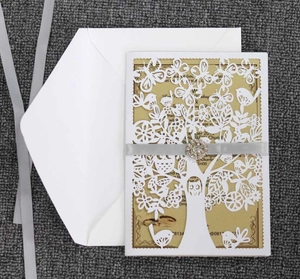 Detail of laser-cut tree and bird cover with gold inner card and rhinestone ribbon