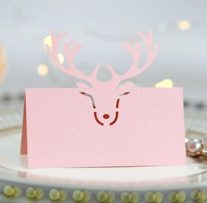 Detail of pink pearlescent reindeer place card with laser-cut antlers for Christmas table décor