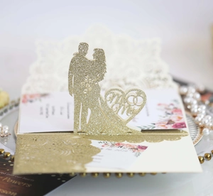 Vista macro dell'invito di nozze glitterato oro con dettaglio a cuore Mr & Mrs