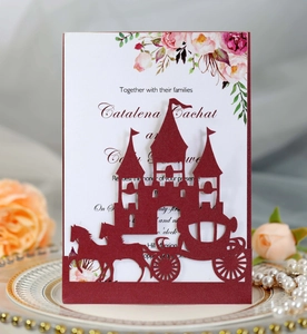 Detailed laser-cut wine red wedding invitation with elegant castle and carriage motif