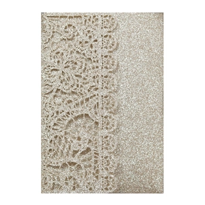 Detail of champagne gold laser-cut invitation with shimmering glitter floral patterns