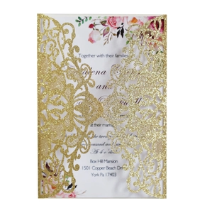 Macro view of laser-cut glitter gold wedding invitation with intricate lace hollow patterns