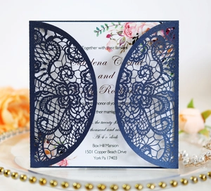 Detail of laser-cut navy blue wedding invitation with elegant floral inner card and lace pattern