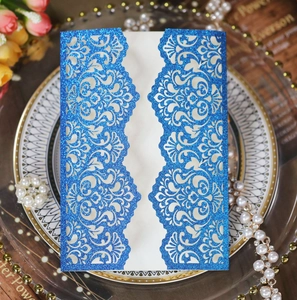 Detail of royal blue glitter paper wedding invitation with laser cut baroque pattern