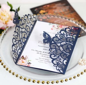 Macro detail of navy blue laser-cut wedding invitation with butterfly lace pattern