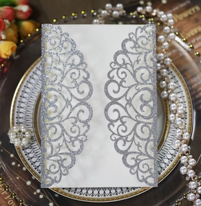 Detailed laser-cut wedding invitation with silver glitter baroque patterns and floral lace