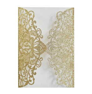 Macro shot of laser-cut hollow pattern on glittery gold wedding invitation card