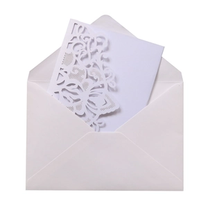 Detail of white laser-cut floral wedding invitation with premium envelope and card