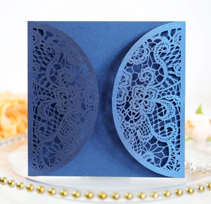 Detail of dark blue laser-cut floral wedding invitation with shimmering pearl paper finish