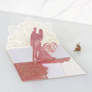 Dettaglio dell'invito di nozze 3D glitter oro rosa con silhouette tagliata al laser