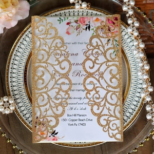 Detail of laser-cut glitter gold wedding invitation with floral inner card and pearls
