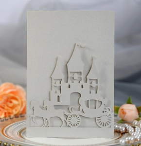 Intricate laser-cut wedding invitation featuring a castle and pumpkin carriage design