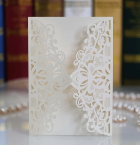Detailed laser-cut floral pattern on off-white pearlescent wedding invitation cover