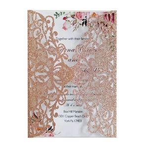 Detail of laser-cut rose gold glitter wedding invitation with floral vine pattern
