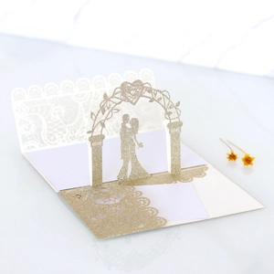 Detail of laser-cut lace edge and 3D silhouette of bride and groom in gold glitter