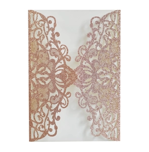 Macro shot of rose gold glitter laser-cut invitation sleeve with floral patterns
