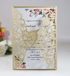 Detail of laser-cut gold glitter wedding invitation with elegant floral inner card