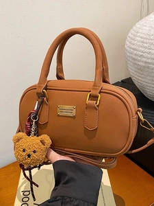 Caramel brown leather bowling handbag with cute bear charm and adjustable strap