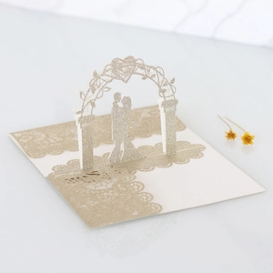 Detailed 3D laser-cut wedding card featuring a romantic silhouette and champagne glitter