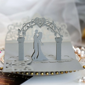 Detailed laser-cut 3D wedding invitation with kissing couple under a heart arch