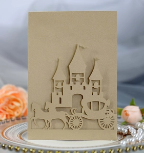 Detail of laser-cut golden castle and horse carriage on premium pearl paper wedding card