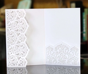Detailed close-up of intricate laser-cut vintage patterns on a white luxury card