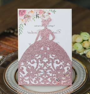 Macro view of pink glitter laser cut wedding invitation with elegant floral details