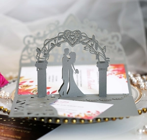 Macro shot of 3D laser cut wedding card with gray hollow sleeve and romantic silhouette