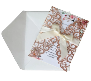 Detail of rose gold laser cut wedding invitation with glitter sleeve and silk ribbon bow