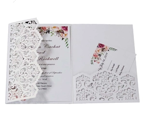 Macro shot of laser-cut floral wedding invitation with watercolor flower insert and RSVP card