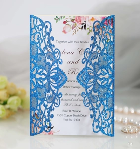 Detail of laser cut blue glitter wedding invitation with elegant floral insert