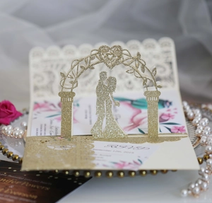 Macro detail of gold glitter 3D laser-cut wedding invitation card with floral insert