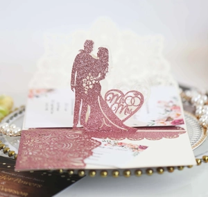 Dettaglio della partecipazione di nozze rosa glitterata con silhouette 3D laser