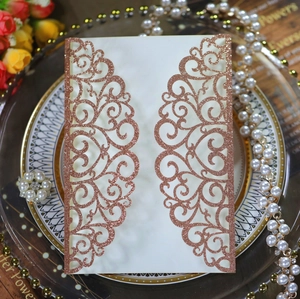 Detail of rose gold laser-cut lace wedding invitation with glitter texture and floral pattern