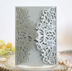 Detail of laser-cut silver lace invitation card with metallic finish on elegant decor