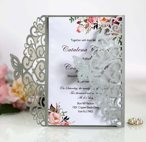 Detail of laser-cut butterfly lace pattern on silver glitter wedding invitation card