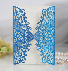 Close-up of glitter blue laser-cut floral invitation with pearl and flower accents