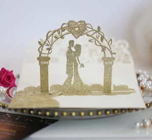 Détail macro d'une carte de mariage 3D découpée au laser avec paillettes dorées et couple