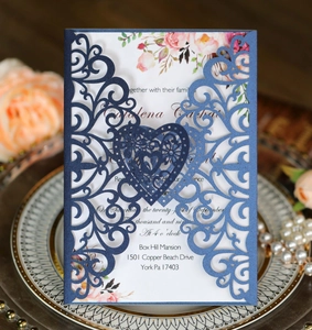 Macro detail of laser-cut heart wedding invitation with navy blue pearlescent shell