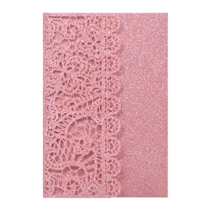 Close-up of pink glitter laser-cut invitation with intricate floral hollow pattern
