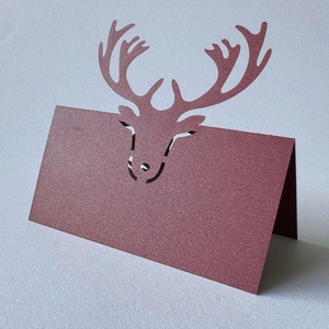 Macro shot of laser-cut reindeer head detail on burgundy pearlescent paper card