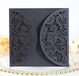 Detail of laser-cut black lace invitation cover with elegant floral hollow patterns