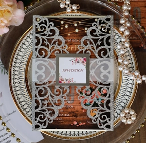 Macro detail of laser-cut silver glitter wedding invitation with floral belly band