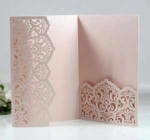 Detail of laser-cut damascus patterns on pearlized light pink wedding invitation card
