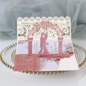 Detail of pink glitter laser cut wedding invitation with 3D couple and floral patterns