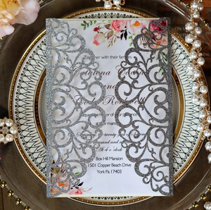 Detailed laser-cut silver glitter invitation cover with elegant floral insert cards
