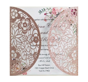 Macro detail of rose gold glitter laser cut wedding invitation with floral patterns