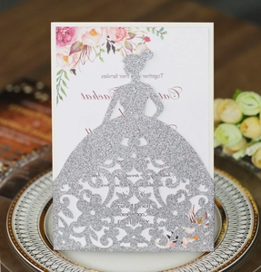 Detail of silver glitter laser-cut bride design wedding invitation on a vintage plate